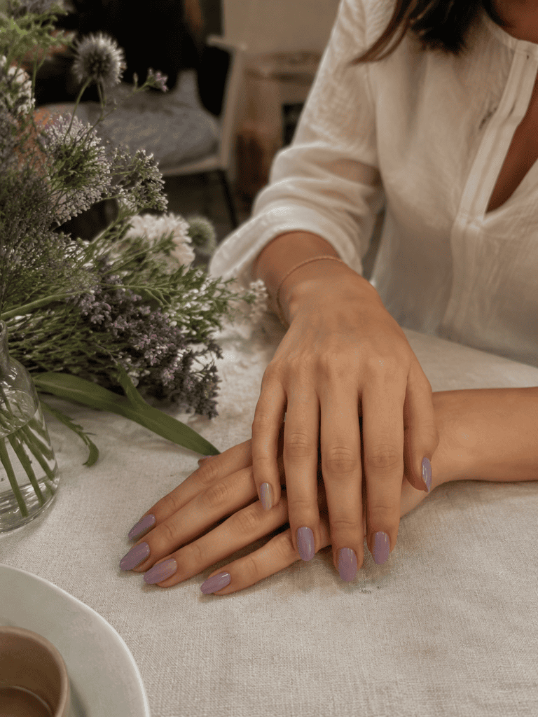 Buttery yellow nails against a white linen shirt in morning light