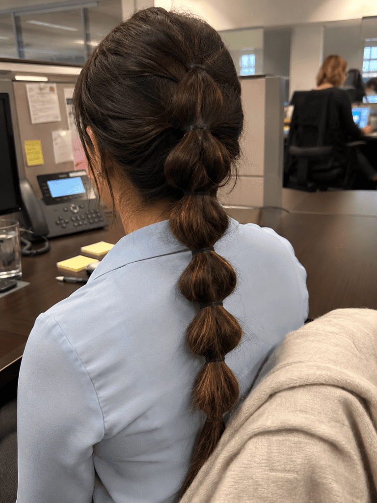 Pull through braid hairstyle worn at an office desk during the workday